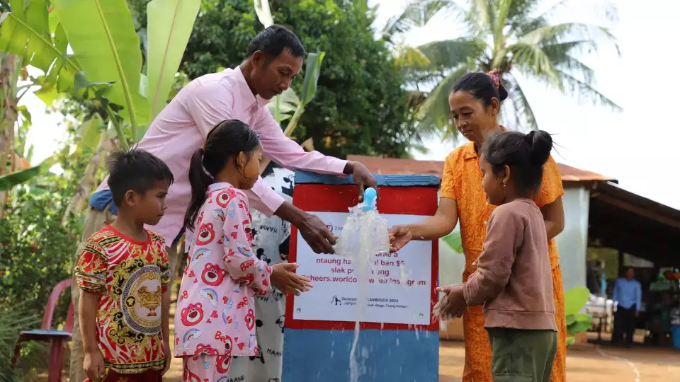 A Cambodian family enjoys fresh water at our water pump.