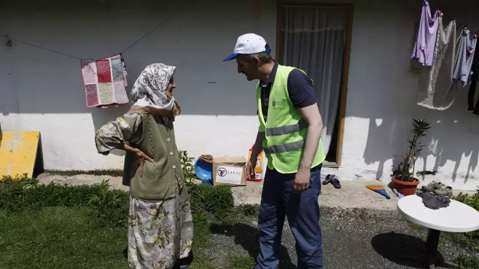 An elderly Bosnian women speaks with our field rep as she receive a food package to ensure she has nourishing meals.