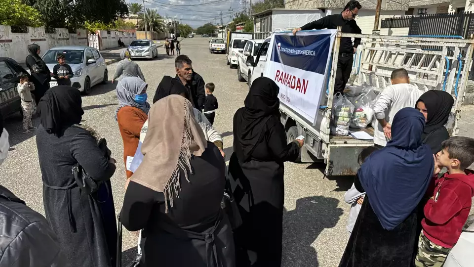 Families in Iraq line up for Ramadan food packages which provide essential items for nourishing meals.