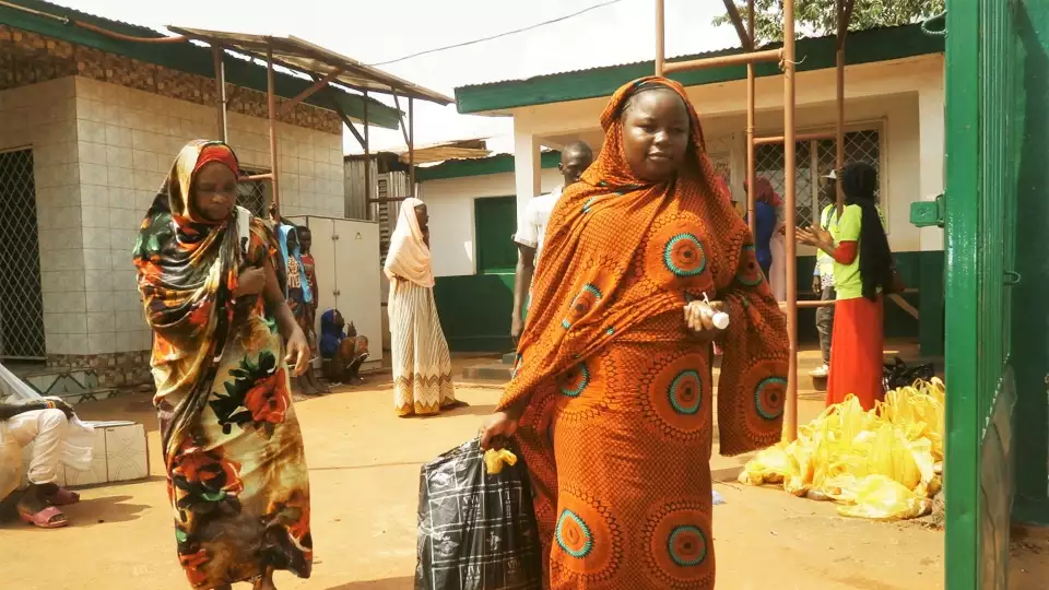Women in CAR leave our distribution site with food packages for their families.