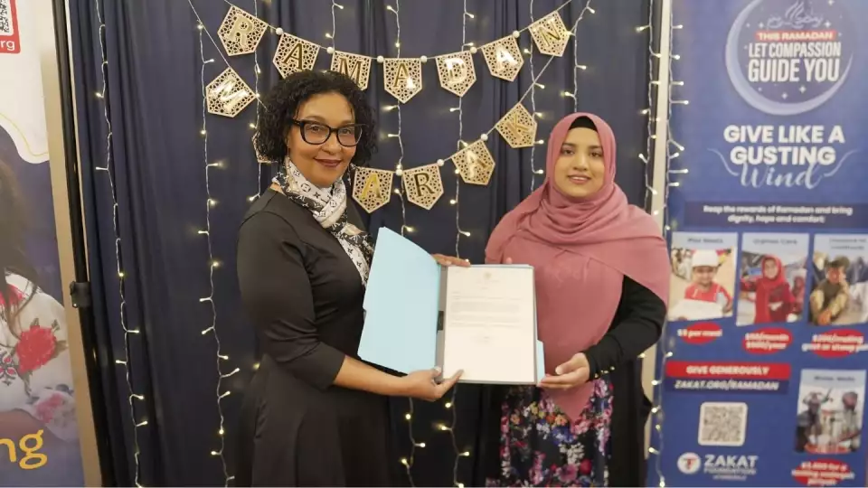 Our NJ Outreach Coordinator accepts a letter from Senator Cory Booker’s office at our Jersey City Iftar, honoring our transformational work in the community. / في نيوجيرسي، تسلمت منسقة التوعية رسالة شكر من مكتب السيناتور كوري بوكر، تكريمًا لجهودنا المجتمعية.