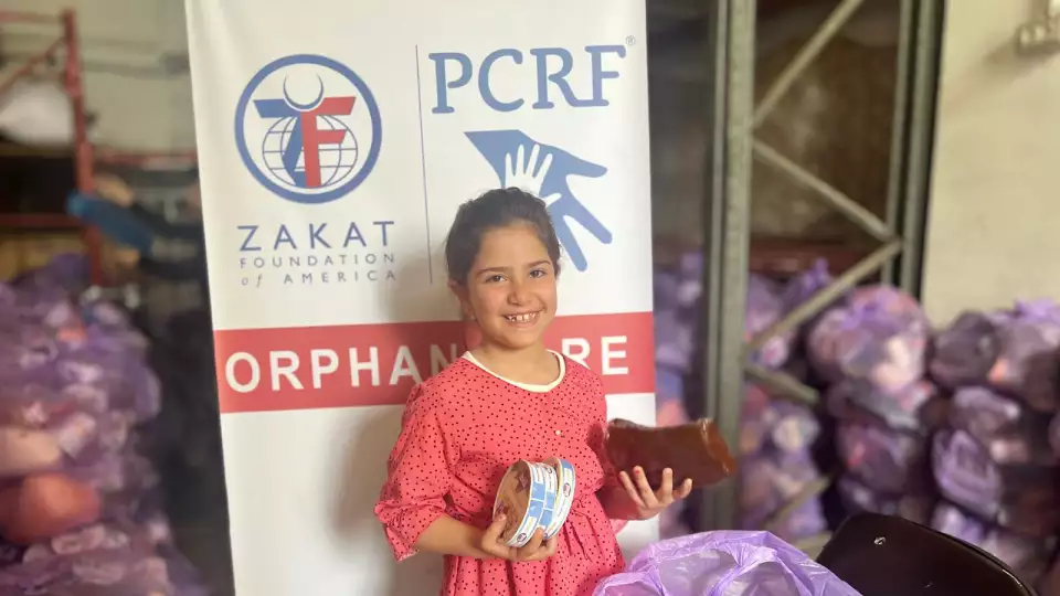 A young Gazan girl is all smiles after being provided essential food supplies.
