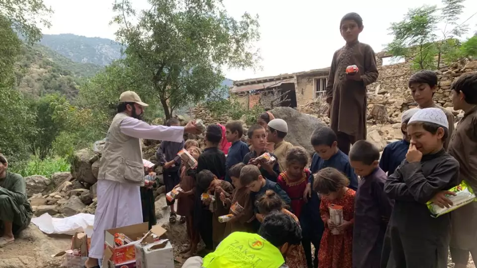 Afghan children gather around our team to receive essentail food items as the search for survivors continues