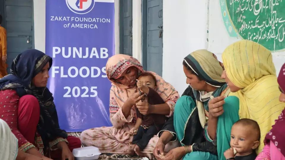 Displaced Pakistan flood affected families eat nourishing meals with their children.