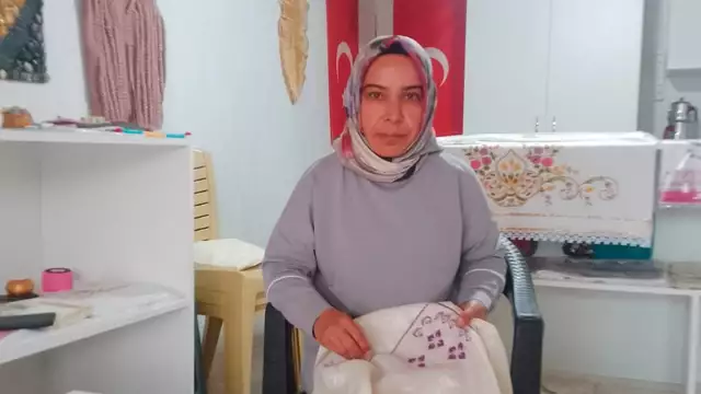 Esma sits with her embroidery project
