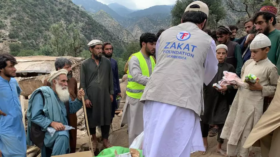 Families surround our team member as emergency food is distributed to earthquake survivors